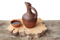 Wine jug and clay cup on the wooden table Royalty Free Stock Photo