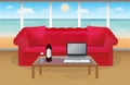 Wine and laptop in front of red sofa in a room with beach background Royalty Free Stock Photo