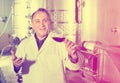 Wine maker controls quality of wine Royalty Free Stock Photo