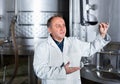 Wine maker controls quality of wine Royalty Free Stock Photo