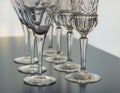 Wine and martini glasses set up in verticle rows on a reflective table top
