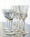 Wine and martini glasses set up in verticle rows on a reflective table top