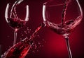 Wine pouring into wineglass on dark red background