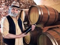 Wine producer showing his bottle of wine in front of the barriq