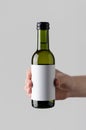 Wine Quarter / Mini Bottle Mock-Up. Blank Label - Male hands holding a wine bottle on a gray background