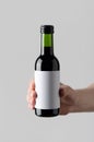 Wine Quarter / Mini Bottle Mock-Up. Blank Label - Male hands holding a wine bottle on a gray background