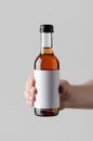 Wine Quarter / Mini Bottle Mock-Up. Blank Label - Male hands holding a wine bottle on a gray background Royalty Free Stock Photo