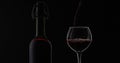 Rose wine. Red wine pour in wine glass over black background. Silhouette Royalty Free Stock Photo