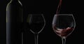 Rose wine. Red wine pour in wine glass over black background. Silhouette Royalty Free Stock Photo