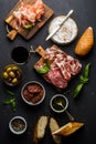 Wine snack set. Glass of red, meat selection, mediterranean olives, sun-dried tomatoes, baguette slices, camembert