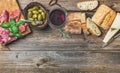 Wine snack set and glass of red over wooden background