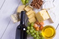 Wine with snacks - various types of cheese, figs, nuts, honey, grapes on a wooden boards background Royalty Free Stock Photo