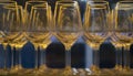 Wine stemware close-up behind glass in a restaurant, out of focus. In yellow and blue colors. Royalty Free Stock Photo