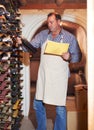 Wine, stock and counting with a man in a cellar for the storage or production of alcohol on a farm. Industry, paper and Royalty Free Stock Photo