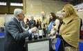 Wine tasting. Customers standing in front of a counter with glasses in hands, man seller communicating. Kyiv, Ukraine