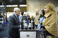 Wine tasting. Customers standing in front of a counter with glasses in hands, seller communicating