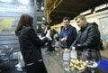 Wine tasting. Customers standing in front of a counter with glasses in hands, seller communicating