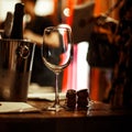 Wine tasting: an empty glass stands on the tasting table next to brochures, champagne corks and silver buckets.