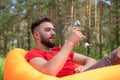 Wine tasting, sommelier looks at a glass of wine. young bearded guy is resting, holding a glass with an alcoholic drink