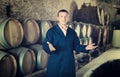 Wine technician working in storage with wooden barrels