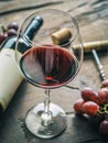Wine testing. Wine glass, grapes and bottle opener on old wooden table Royalty Free Stock Photo