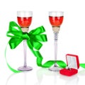 Wine in two wineglasses with green satin bow and wedding rings Royalty Free Stock Photo