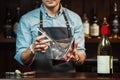 Wineglass at bar counter at background of sommelier with decanter with wine