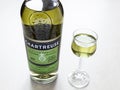 Wineglass and bottle of green Chartreuse liqueur