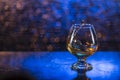 Wineglass of cognac and splash on a blue bokeh background