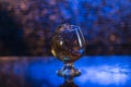 Wineglass of cognac and splash on a blue bokeh background
