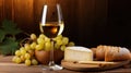 Wineglass with natural white wine, fresh grape vine, cut cheese head and bread on wooden table, close-up, selected focus Royalty Free Stock Photo