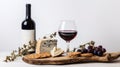 Wineglass with red wine, wine bottle, cheese with mold, bread, biscuits and herbs on wooden cutting board. Royalty Free Stock Photo