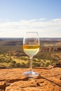 Wineglass on a table in the desert with mountains in the background. Australian wine concept. Royalty Free Stock Photo