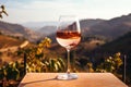 Wineglass on table in vineyard in Tuscany, Italy, A chilled glass of rosÃÂ© wine against a backdrop of vineyards, AI Generated Royalty Free Stock Photo