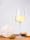 A wineglass of white dry wine and camembert cheese on a wooden table. Close-up. Selective focus Royalty Free Stock Photo