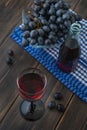 A wineglass of young red Fresh wine with glass bottle and a bunch of black grapes Royalty Free Stock Photo
