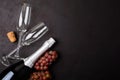 Wineglasses, grapes and bottle of champagne lying on black wooden background. New Year celebration concept. Top view. Flat lay