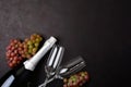 Wineglasses, grapes and bottle of champagne lying on black wooden background. New Year celebration concept.