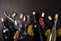 Wineglasses with red and white wine, bottles, grapes, corkscrew and corks lying on dark wooden background. Top view. Flat lay. Cop Royalty Free Stock Photo
