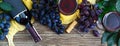 Wineglasses with red wine, bottle, corkscrew, blue grapes, leaves on a wooden table. Wine background with copy space. Top view, Royalty Free Stock Photo