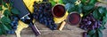 Wineglasses with red wine, bottle, corkscrew, blue grapes, leaves on a wooden table. Wine background with copy space. Top view, Royalty Free Stock Photo