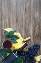 Wineglasses with red wine, bottle, corkscrew, blue grapes, leaves on a wooden table. Wine background with copy space. Top view, Royalty Free Stock Photo