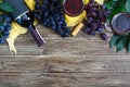 Wineglasses with red wine, bottle, corkscrew, blue grapes, leaves on a wooden table. Wine background with copy space. Top view, Royalty Free Stock Photo