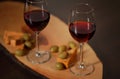 Wineglasses with red wine on wood with cheese and green olives - for cozy home evening Royalty Free Stock Photo