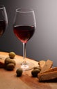 Wineglasses with red wine on wood with cheese and green olives. studio background Royalty Free Stock Photo