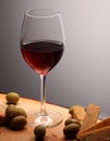 Wineglasses with red wine on wood with cheese and green olives. studio background Royalty Free Stock Photo