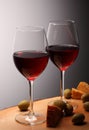 Wineglasses with red wine on wood with cheese and green olives. studio background Royalty Free Stock Photo