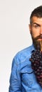 Winegrower showing half of his face holds cluster of grapes. Royalty Free Stock Photo