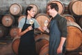 Winemaker business partners having fun talking at winery, white wine tasting and laugh. Young sommelier testing flavor