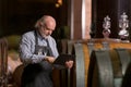 Winemaker checking a wine aging in barrels data, using a touchpad tablet